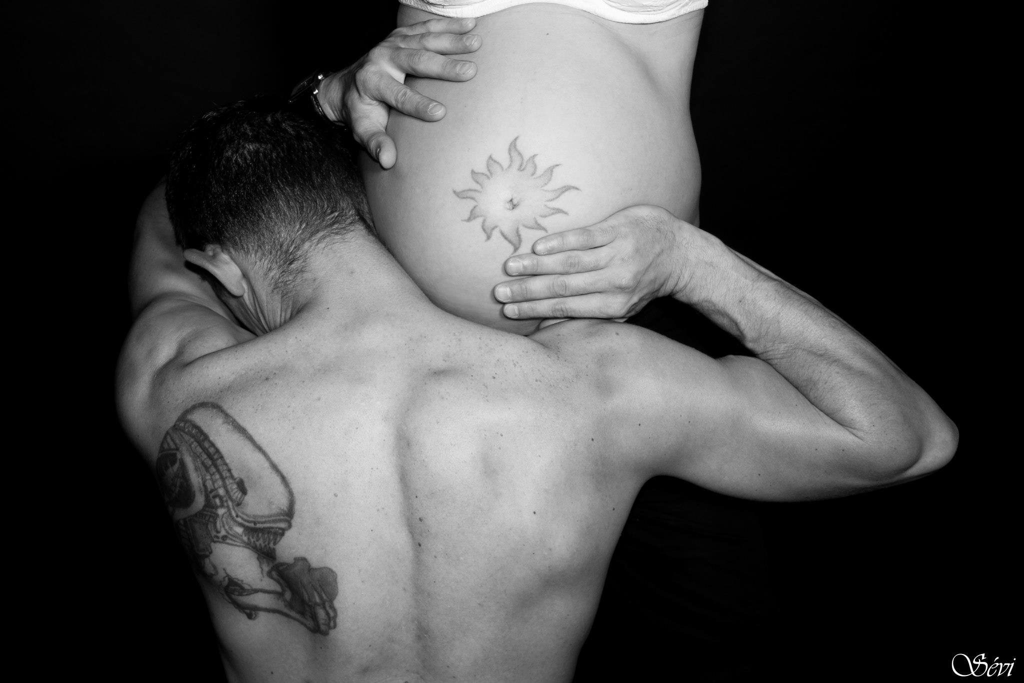 Photo grossesse papa tient ventre sur son épaule tatouage