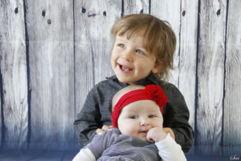 Photo frère et sœur studio fond bois famille noel sapin séance photo studio