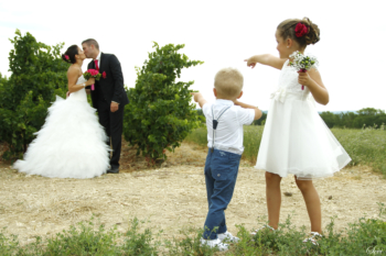 Photo mariage originale enfants montrent mariés qui s'embrassent