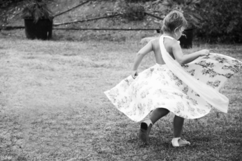 Photo enfant fille danse et fait tourner sa robe nature