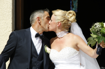 Photo mariage couple s'embrasse sortie mairie