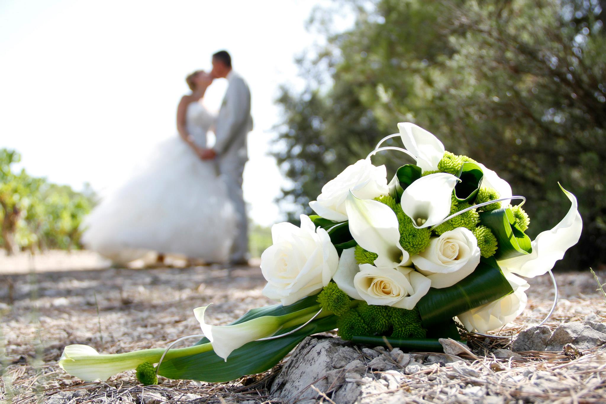 Photo mariage bouquet net devant mariés flous derrière
